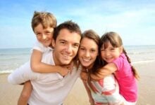 Familia disfrutando de una playa durante un viaje