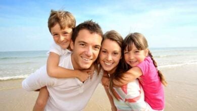 Familia disfrutando de una playa durante un viaje