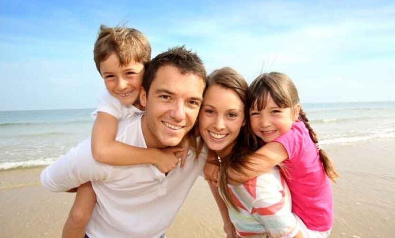 Familia disfrutando de una playa durante un viaje