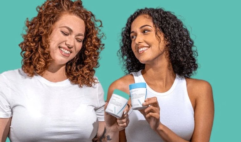 Two women holding Happy V wellness products