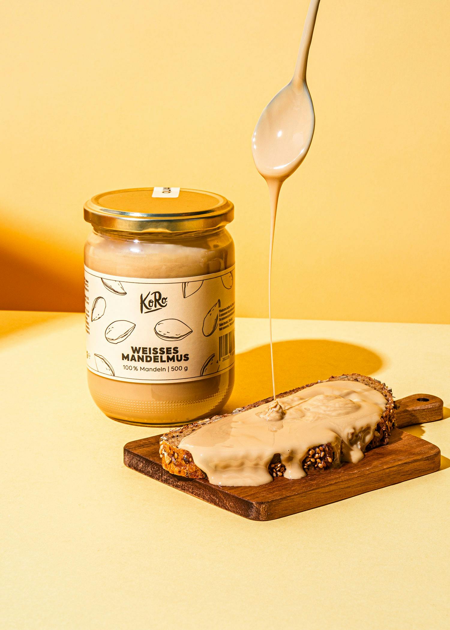 Glas mit weißem Mandelmus und bestrichenem Brot