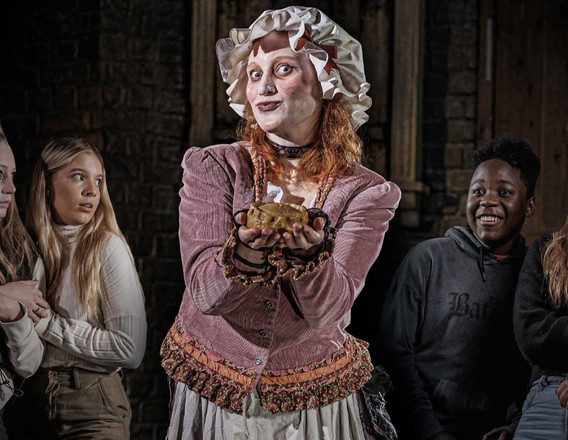 Visitors with an actor in costume at The London Dungeon