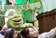 Visitors posing with Shrek at Shrek's Adventure! London