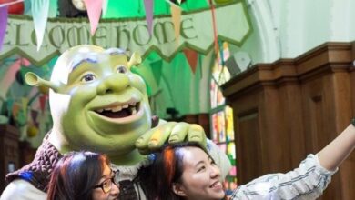 Visitors posing with Shrek at Shrek's Adventure! London