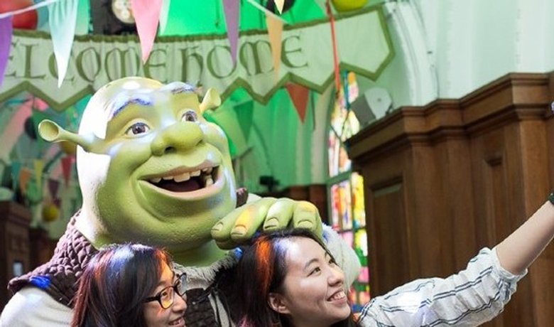 Visitors posing with Shrek at Shrek's Adventure! London