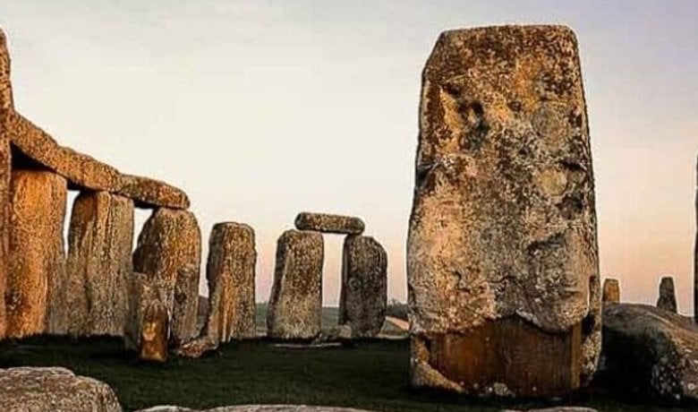 Stonehenge stones at dusk in an open landscape