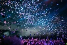 Outdoor travel event scene with a crowd and stage