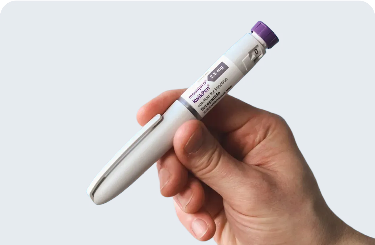 A hand holds a Mounjaro KwikPen injection pen against a blue background