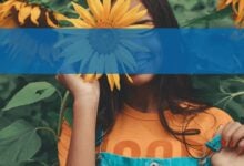 Mujer sosteniendo un girasol al aire libre