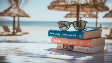 Libros y gafas de sol junto a una escena de viaje