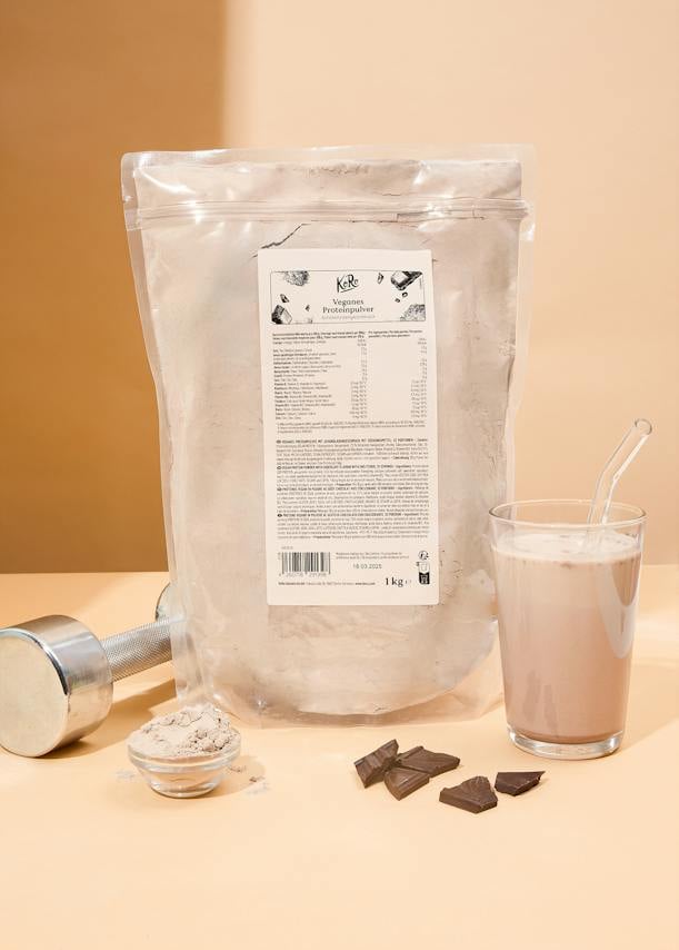 Beutel mit veganem Proteinpulver Schokolade neben Glas und Schokolade