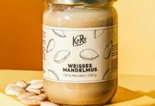 Glas mit weißem Mandelmus neben Brot