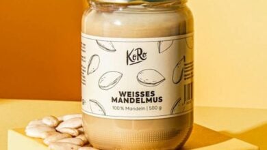 Glas mit weißem Mandelmus neben Brot