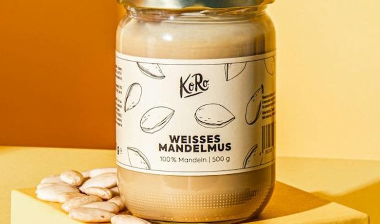 Glas mit weißem Mandelmus neben Brot