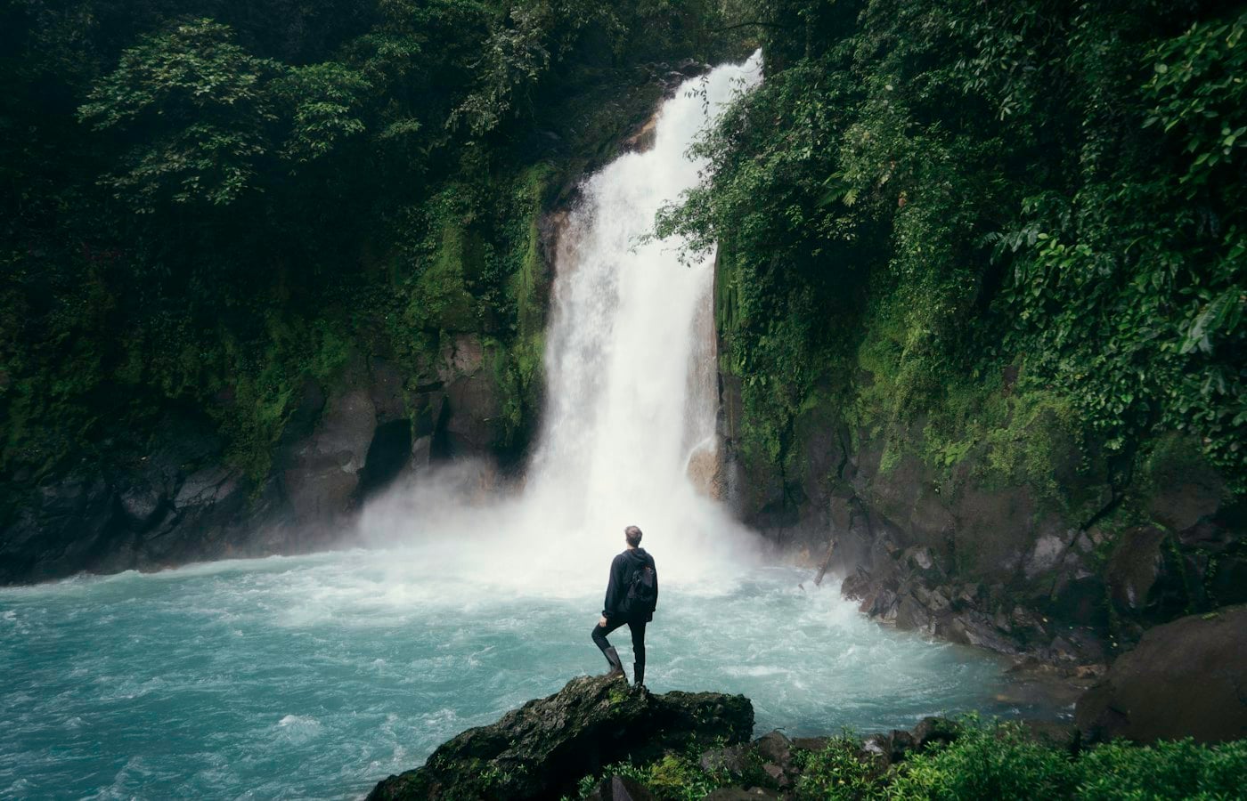 Viajero ante una cascada en un entorno natural